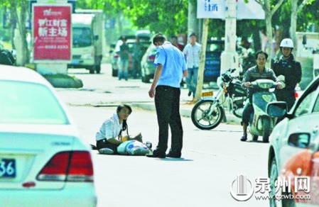 女孩從摩的上摔下，跌坐路中央，恰遇社區(qū)聯(lián)防巡邏人員扶起。