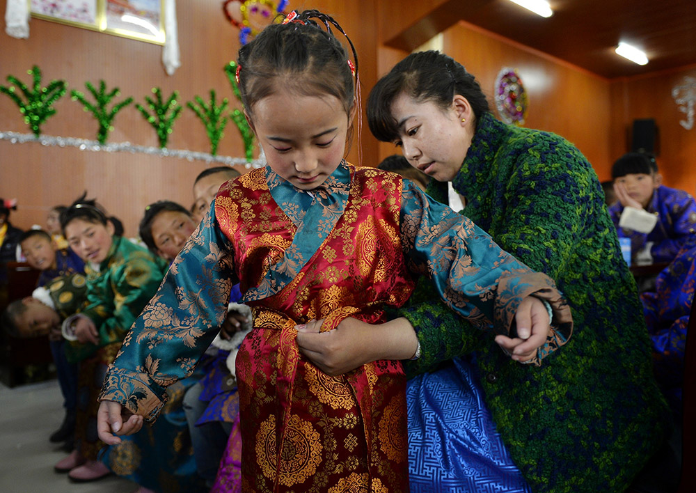 2月27日，在西藏自治區(qū)兒童福利院，來自拉薩市尼木縣的“愛心媽媽”德慶旺姆（右）在為來自那曲地區(qū)的嘎瑪曲宗換上節(jié)日盛裝。